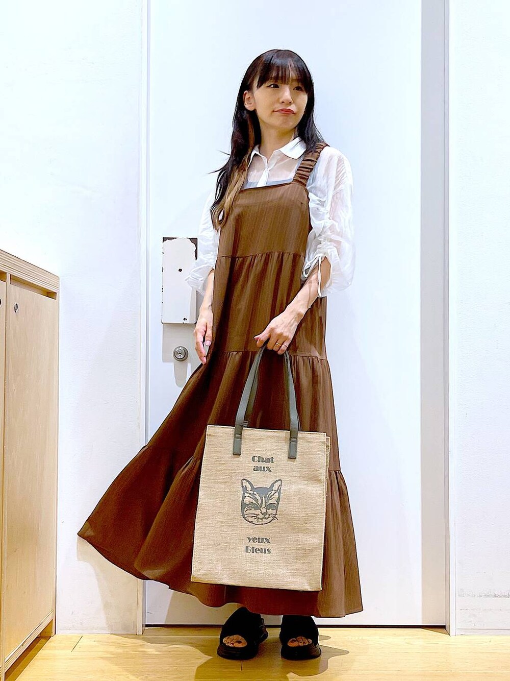 ブラック系のサンダル、ベージュ系のワンピース、グレー系のトートバッグを着用したレディースの夏コーディネートの1枚目の写真