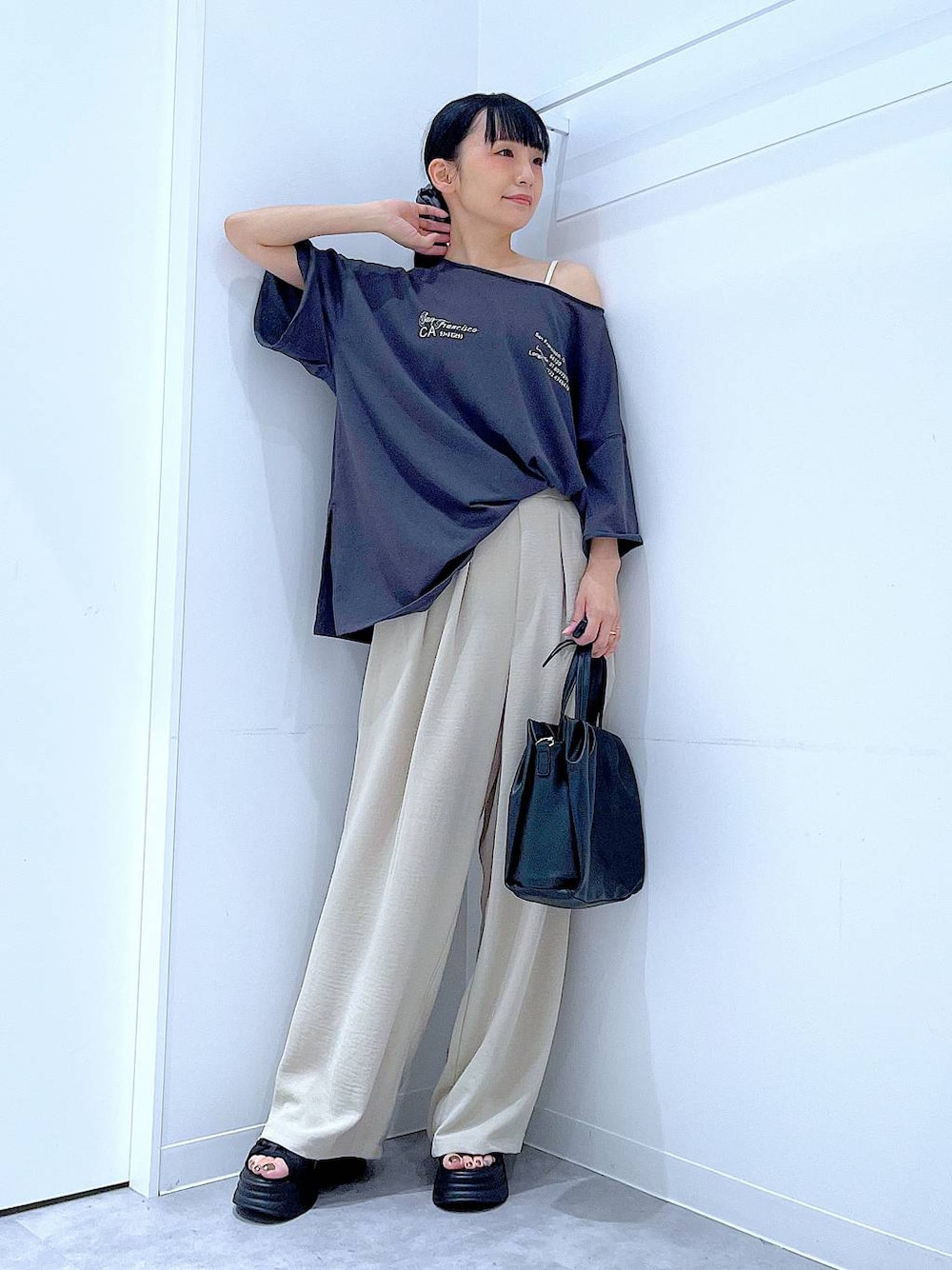 ブラック系のサンダル、ベージュ系のその他パンツ、ブラック系のハンドバッグを着用したレディースの夏コーディネートの1枚目の写真