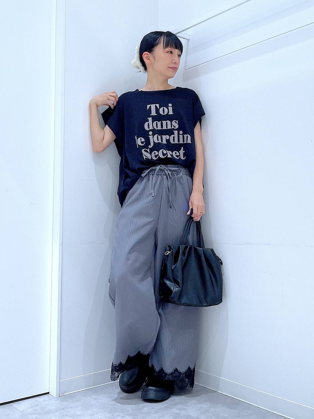 ブラック系のTシャツ/カットソー、グレー系のスラックス、ブラック系のハンドバッグを着用したレディースの秋コーディネートの1枚目の写真