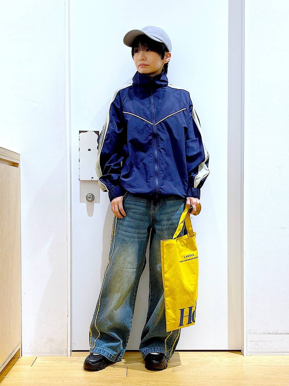 ブラック系のスニーカー、ブルー系のデニムパンツ、ブルー系のブルゾンを着用したレディースの春コーディネートの1枚目の写真