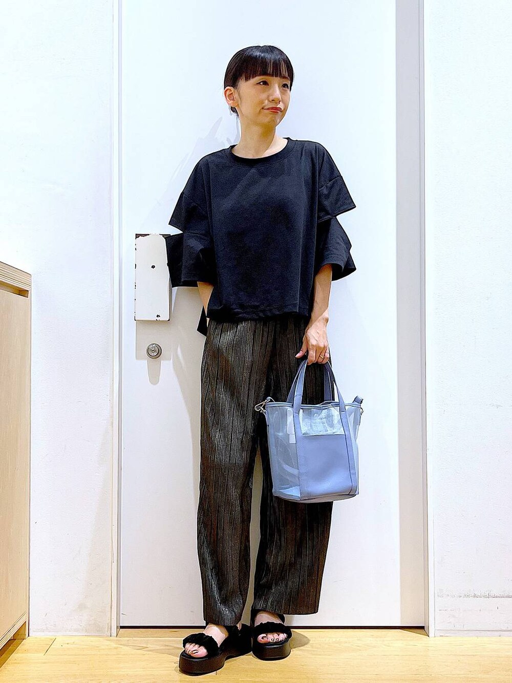 ブラック系のサンダル、ブルー系のトートバッグ、ブラック系のTシャツ/カットソーを着用したレディースの秋コーディネートの1枚目の写真