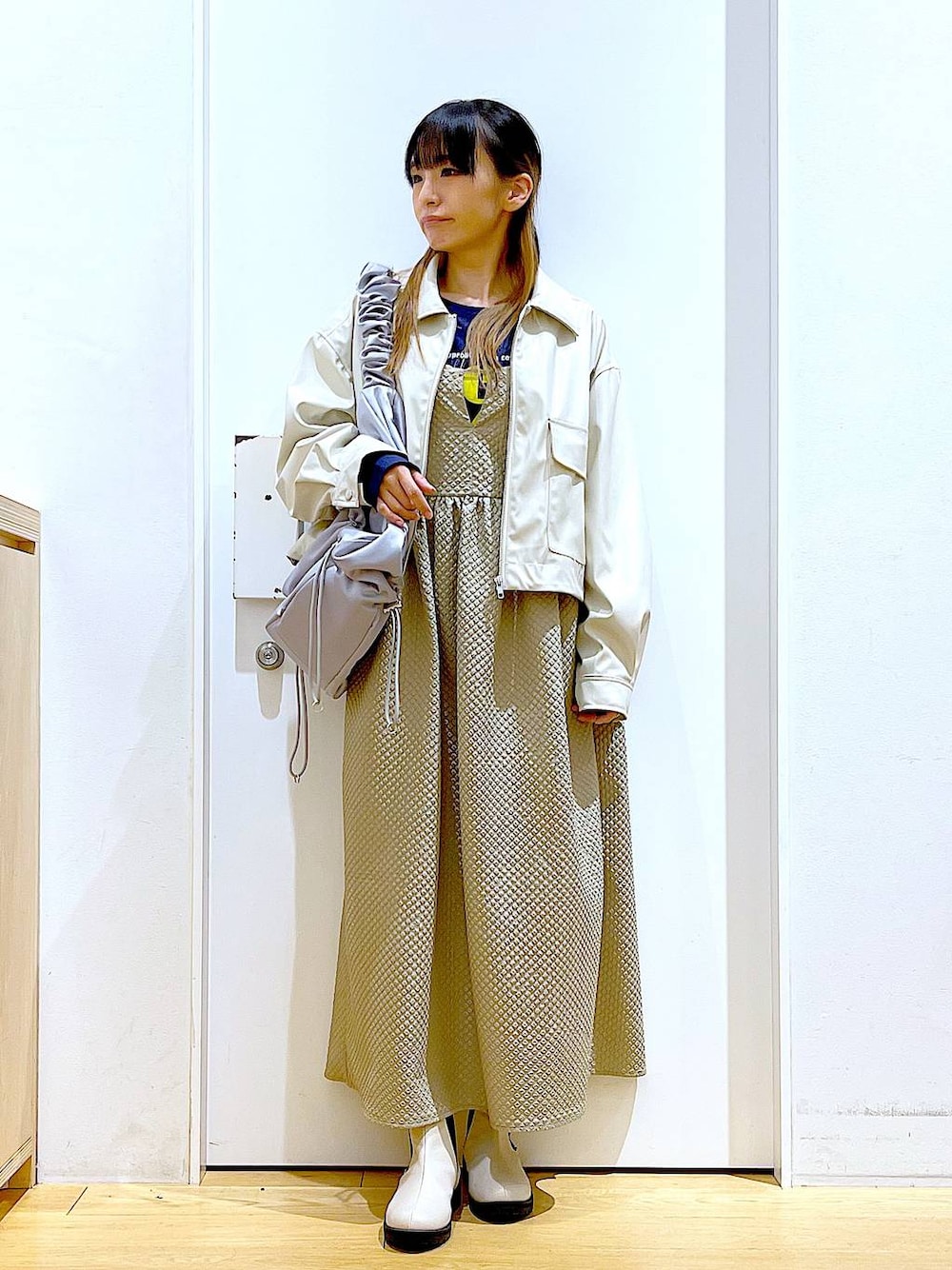 ベージュ系のブルゾン、ブラウン系のワンピース、ブルー系のTシャツ/カットソーを着用したレディースの春コーディネートの1枚目の写真