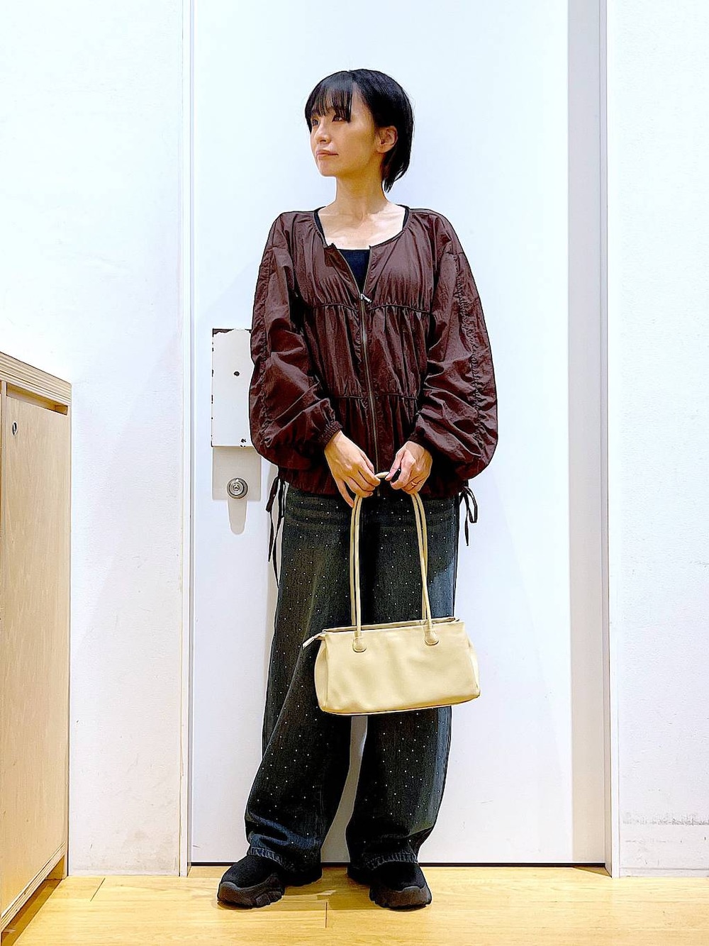 ブラック系のブーツ、ベージュ系のトートバッグ、ブラウン系のブルゾンを着用したレディースの冬コーディネートの1枚目の写真