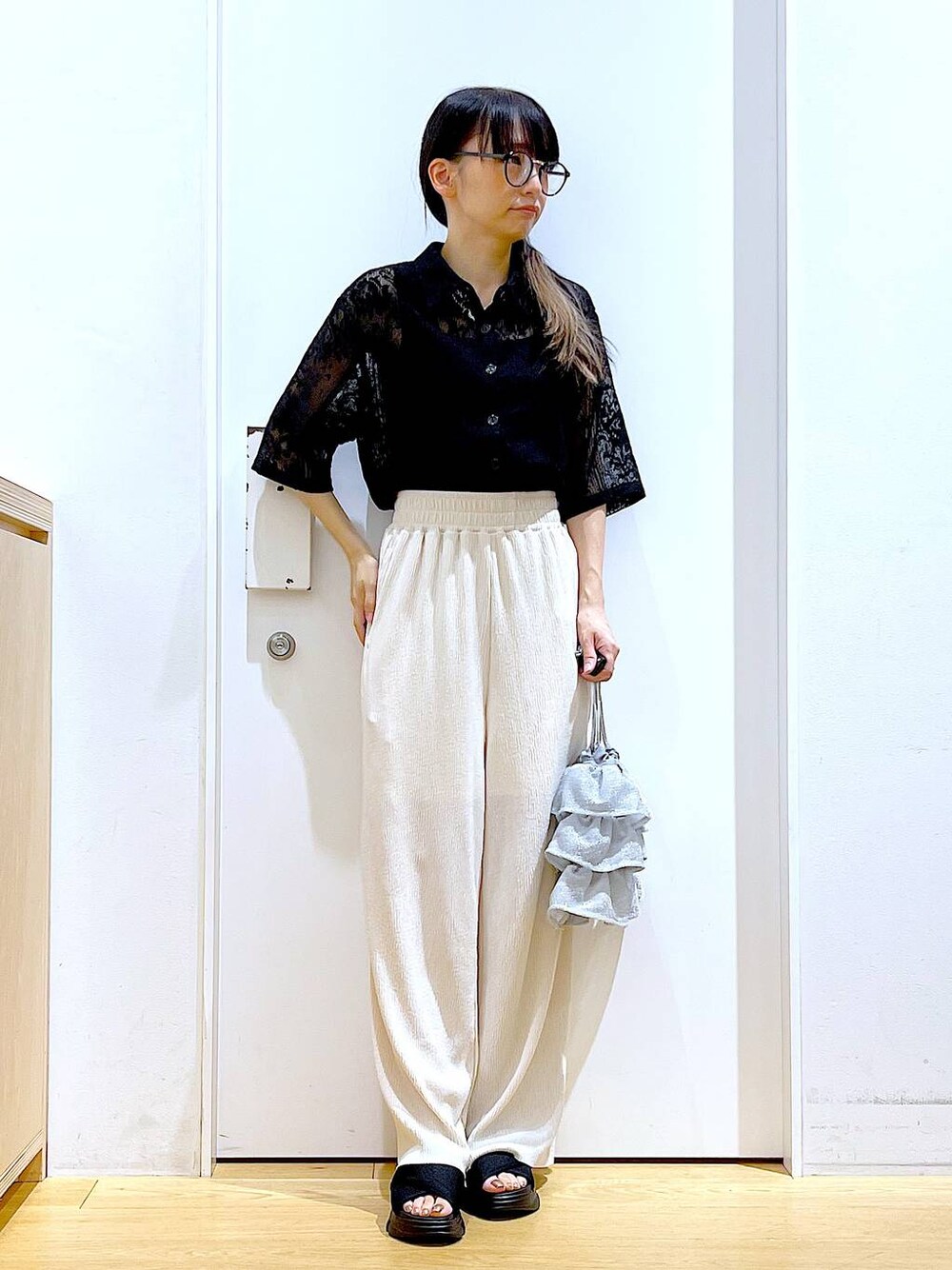 シルバー系のショルダーバッグ、ブラック系のサンダル、ブラック系のシャツ/ブラウスを着用したレディースの夏コーディネートの1枚目の写真