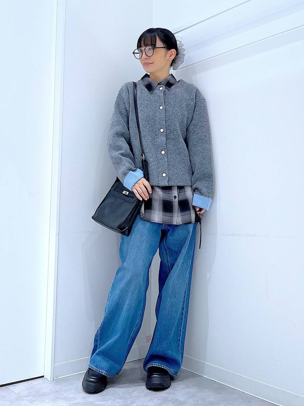 ブルー系のデニムパンツ、ブラック系のシャツ/ブラウス、ブラック系のショルダーバッグを着用したレディースの秋コーディネートの1枚目の写真