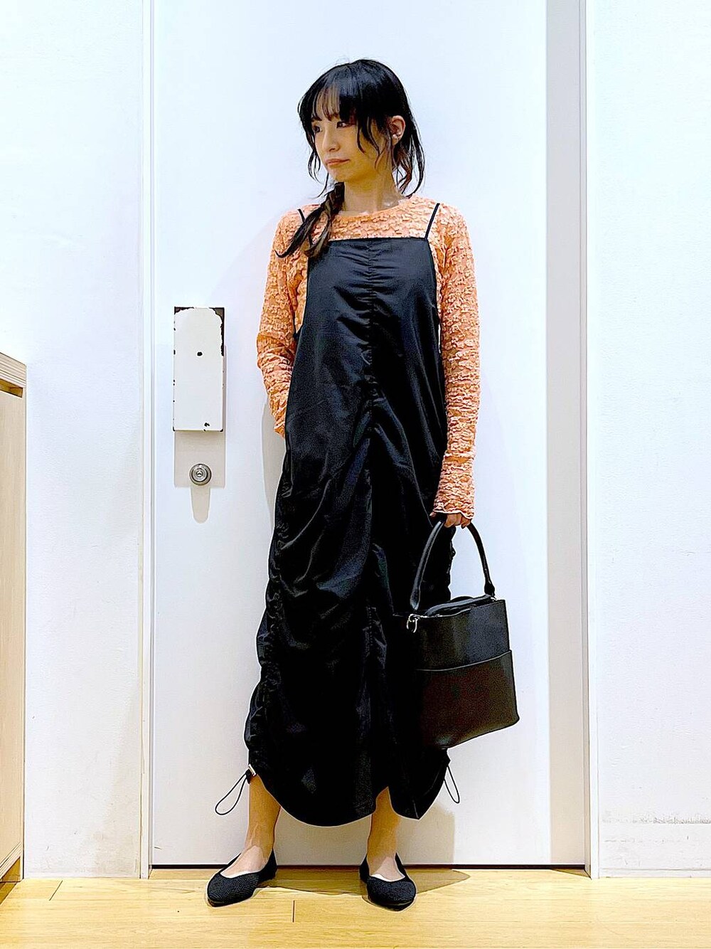 ブラック系のワンピース、ブラック系のショルダーバッグ、ブラック系のパンプスを着用したレディースの春コーディネートの1枚目の写真