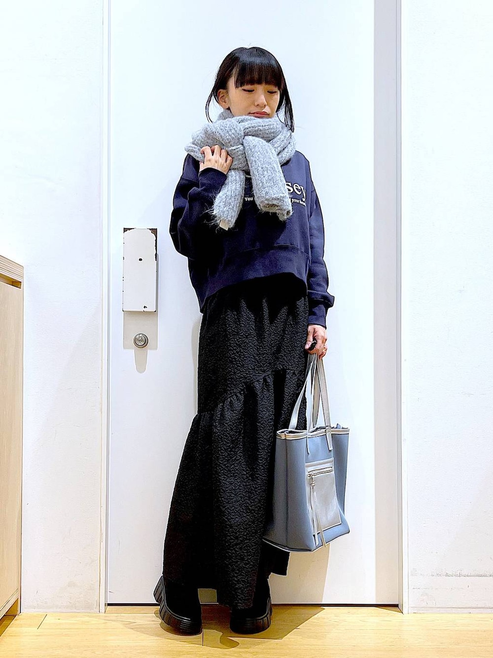 グレー系のトートバッグ、ブラック系のブーツ、グレー系のスウェットを着用したレディースの冬コーディネートの1枚目の写真