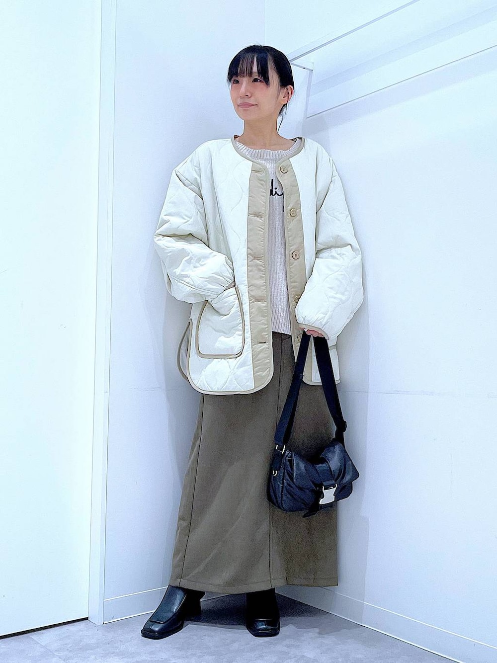 ベージュ系のブルゾン、ブラック系のブーツ、ベージュ系のニット/セーターを着用したレディースの冬コーディネートの1枚目の写真