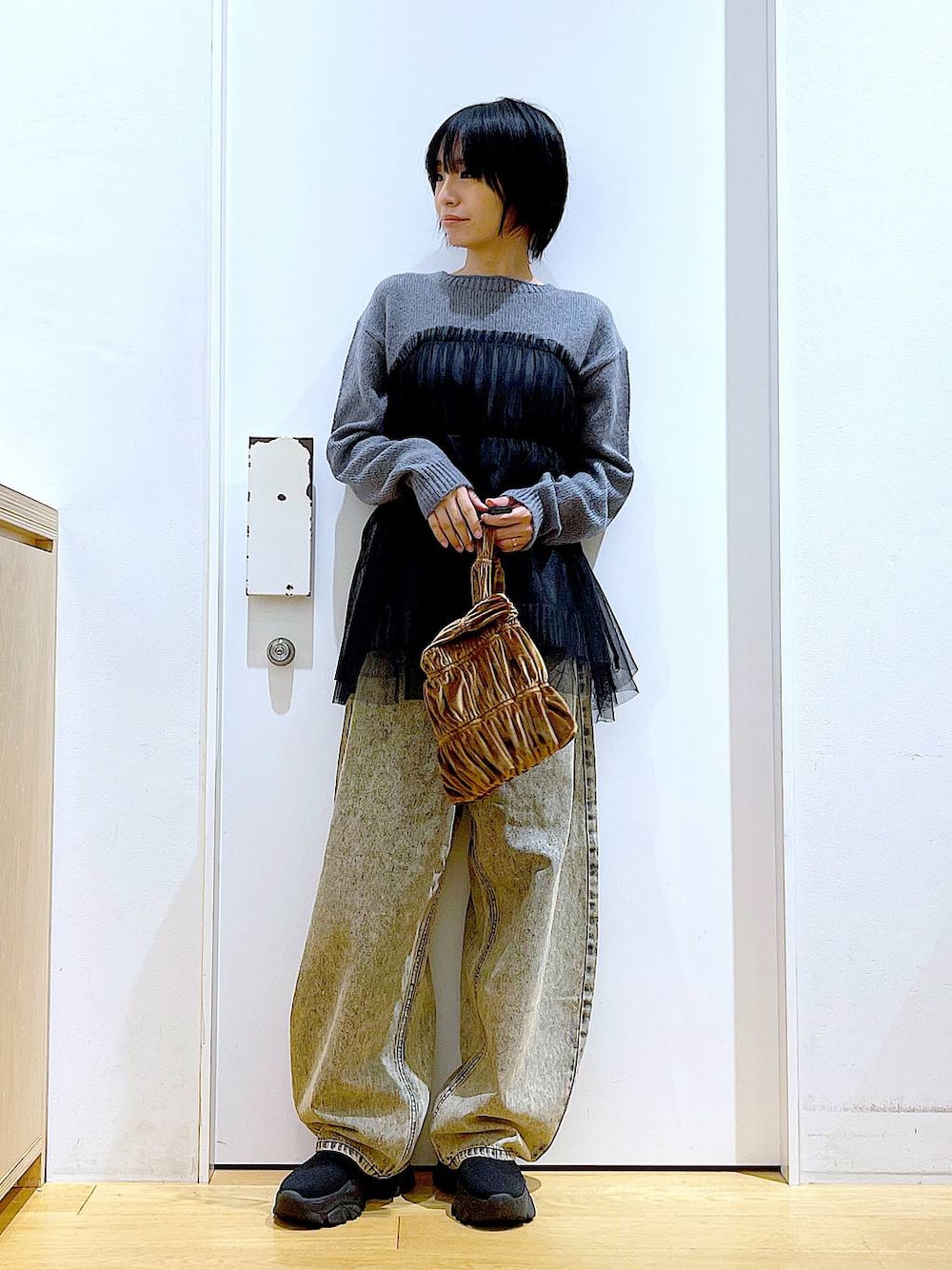 ブラック系のブーツ、イエロー系のショルダーバッグ、ベージュ系のデニムパンツを着用したレディースの秋コーディネートの1枚目の写真