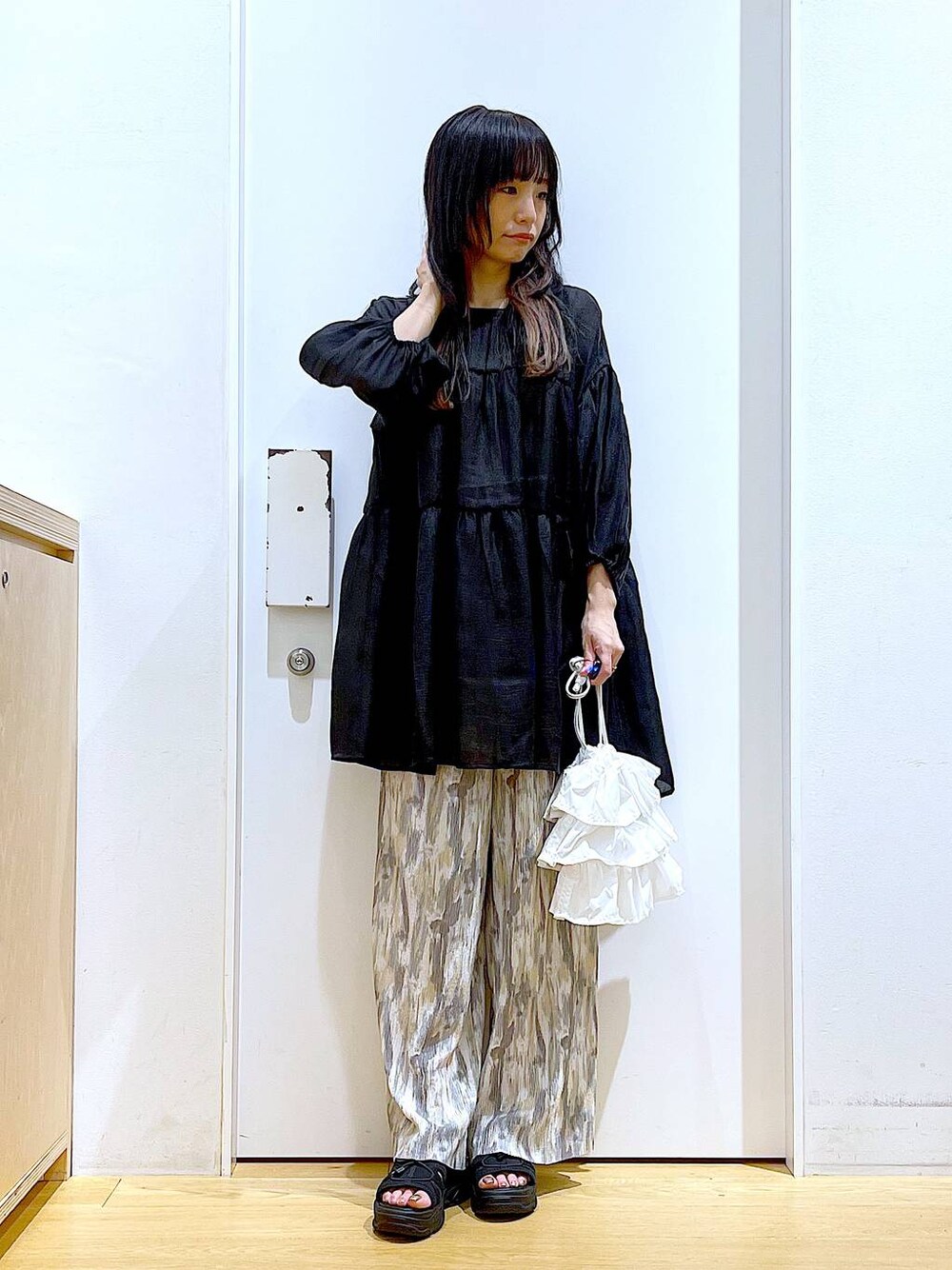 ホワイト系のショルダーバッグ、ブラック系のサンダル、ベージュ系のその他パンツを着用したレディースの夏コーディネートの1枚目の写真