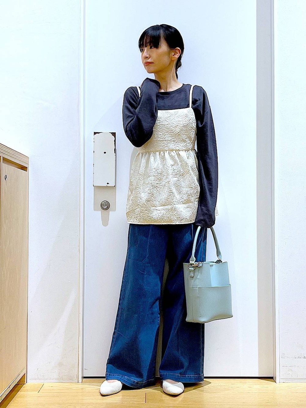 ブルー系のデニムパンツ、ホワイト系のキャミソール、グリーン系のショルダーバッグを着用したレディースの春コーディネートの1枚目の写真
