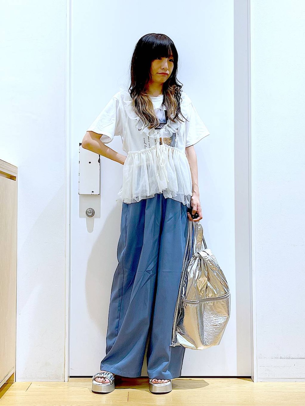 シルバー系のバックパック/リュック、ホワイト系のTシャツ/カットソー、シルバー系のサンダルを着用したレディースの夏コーディネートの1枚目の写真