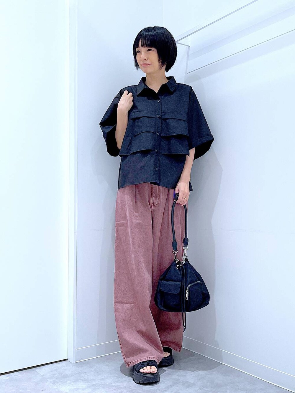 ブラック系のスニーカー、ブラック系のショルダーバッグ、ブラック系のシャツ/ブラウスを着用したレディースの秋コーディネートの1枚目の写真