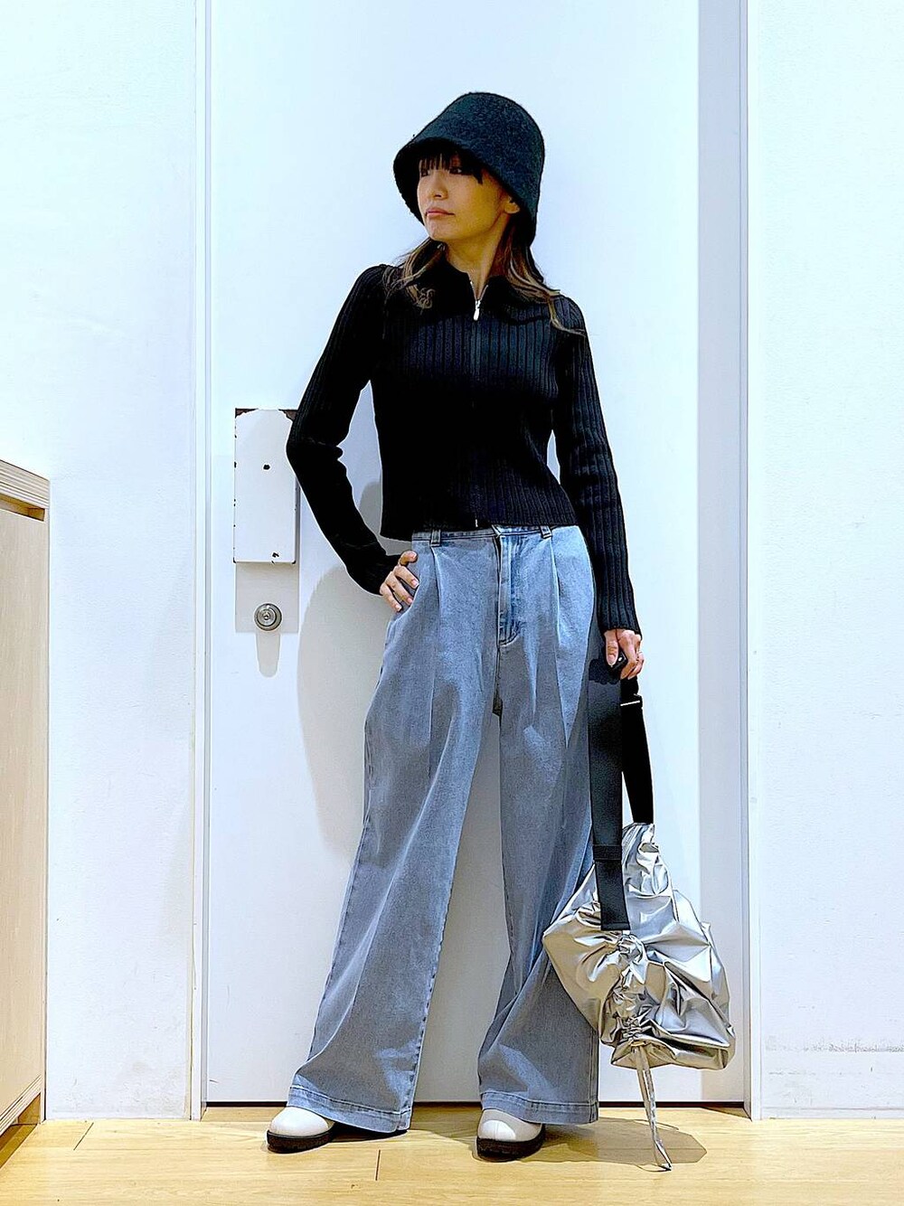 ブルー系のデニムパンツ、ブラック系のカーディガン/ボレロ、ベージュ系のブーツを着用したレディースの冬コーディネートの1枚目の写真