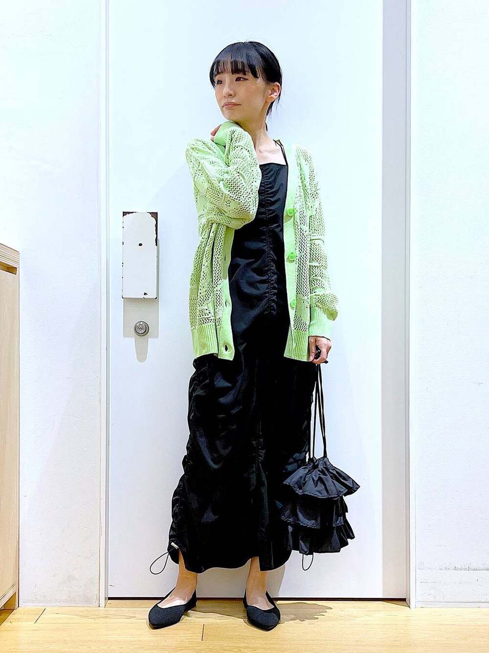 ブラック系のショルダーバッグ、ブラック系のパンプス、ブラック系のワンピースを着用したレディースの春コーディネートの1枚目の写真