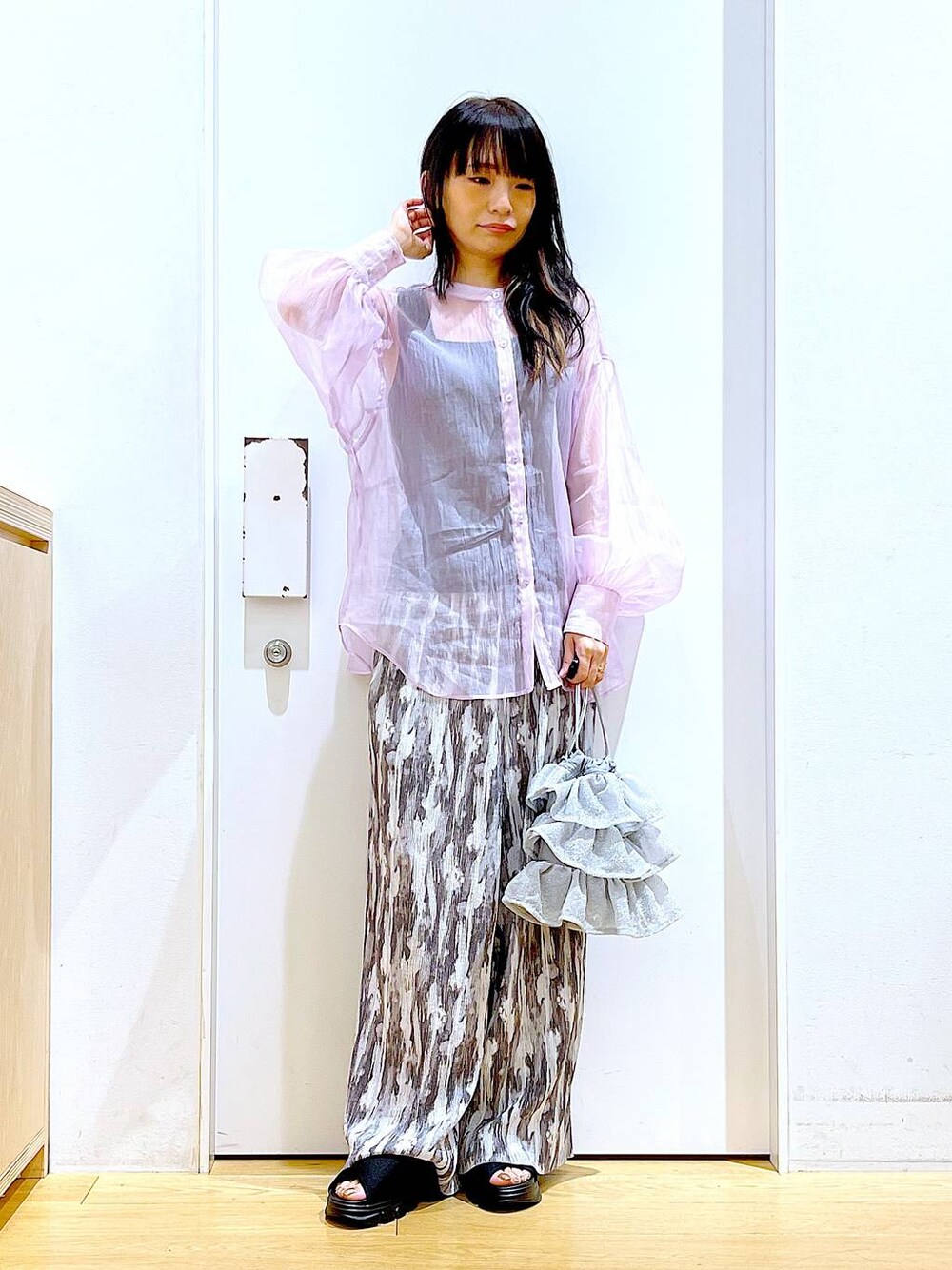 シルバー系のショルダーバッグ、パープル系のシャツ/ブラウス、ブラック系のサンダルを着用したレディースの夏コーディネートの1枚目の写真