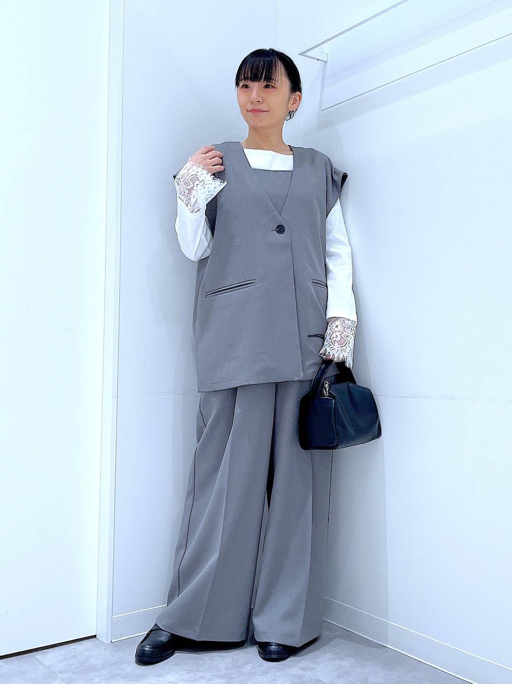 ブラック系のショルダーバッグ、グレー系のサロペット/オーバーオール、グレー系のベストを着用したレディースの冬コーディネートの1枚目の写真