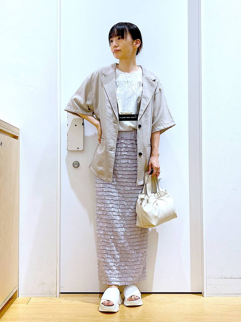 ホワイト系のサンダル、ホワイト系のショルダーバッグ、ホワイト系のTシャツ/カットソーを着用したレディースの夏コーディネートの1枚目の写真