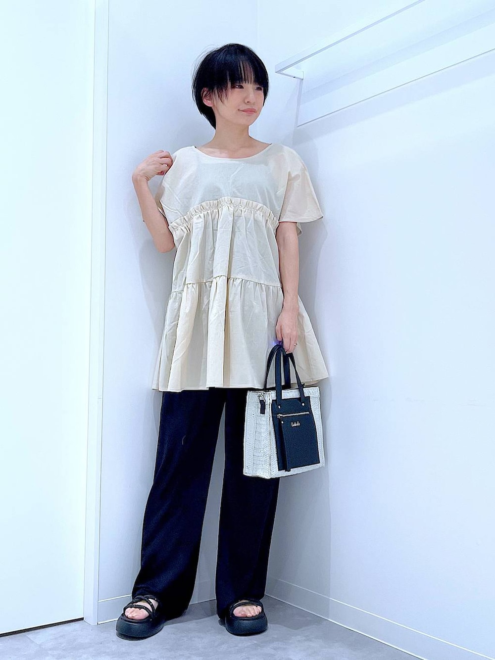 ホワイト系のショルダーバッグ、ブラック系のサンダル、ブラック系のその他パンツを着用したレディースの夏コーディネートの1枚目の写真