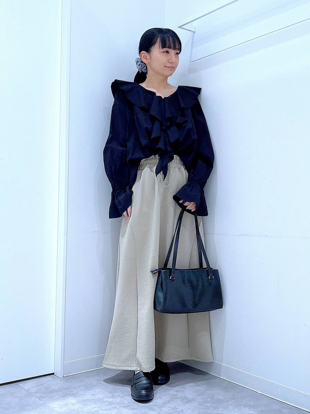 ブラック系のハンドバッグ、ブラック系のローファー、ブラック系のシャツ/ブラウスを着用したレディースの春コーディネートの1枚目の写真