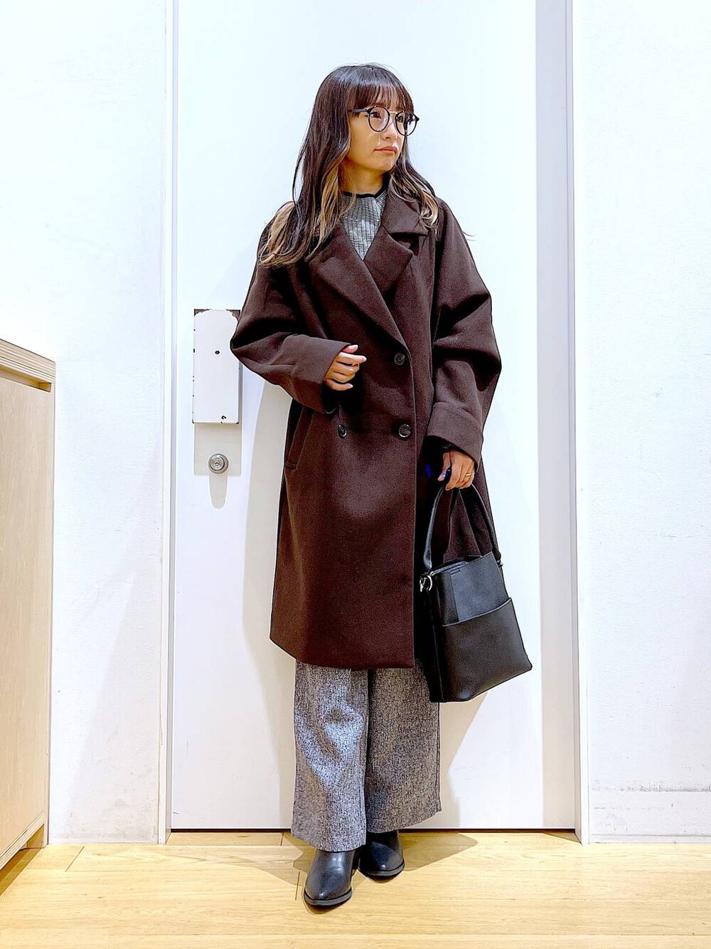 ブラウン系のステンカラーコート、ブラック系のショルダーバッグ、その他のニット/セーターを着用したレディースの冬コーディネートの1枚目の写真