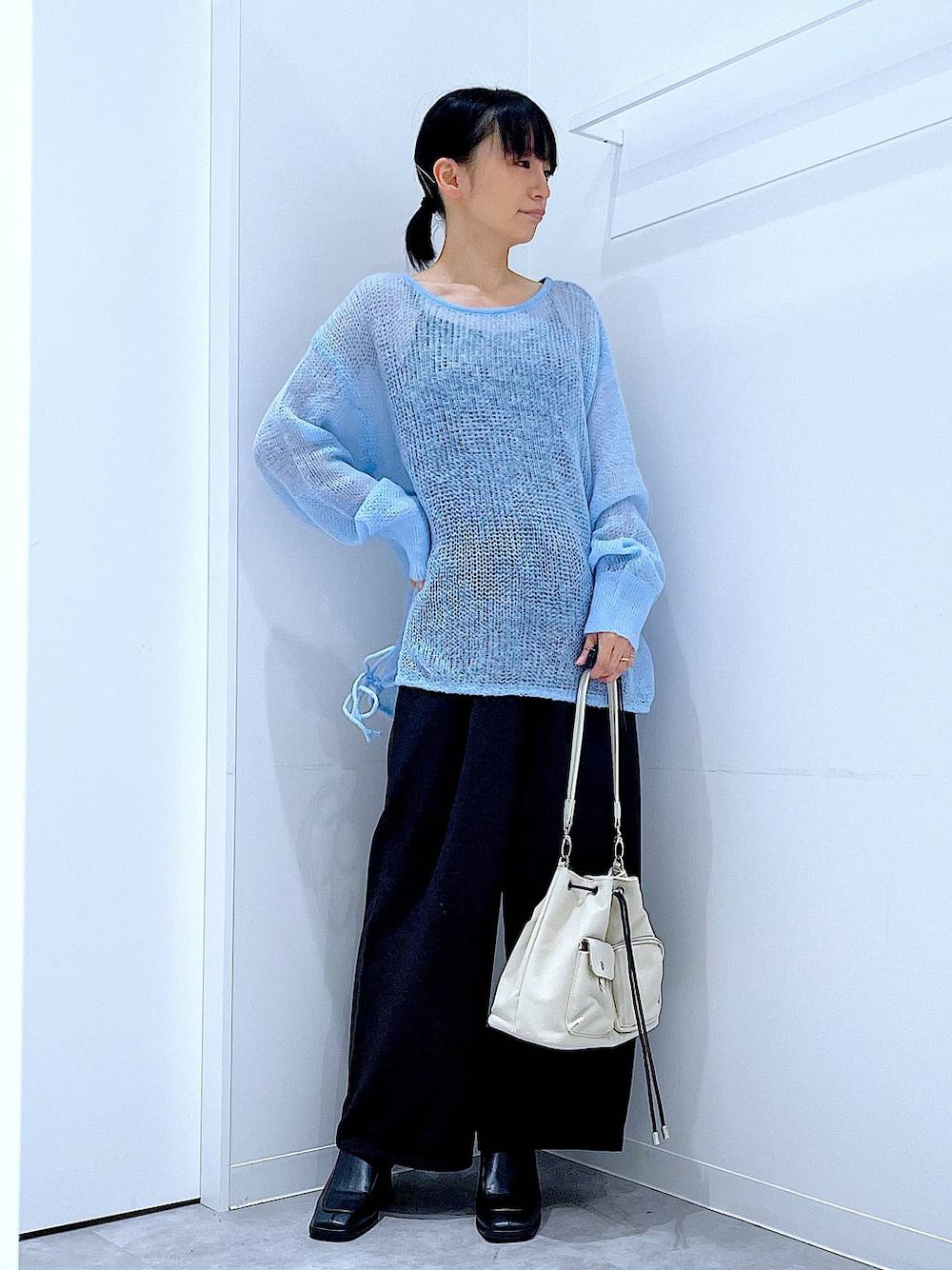 ブラック系のその他パンツ、ホワイト系のショルダーバッグ、ブラック系のブーツを着用したレディースの冬コーディネートの1枚目の写真