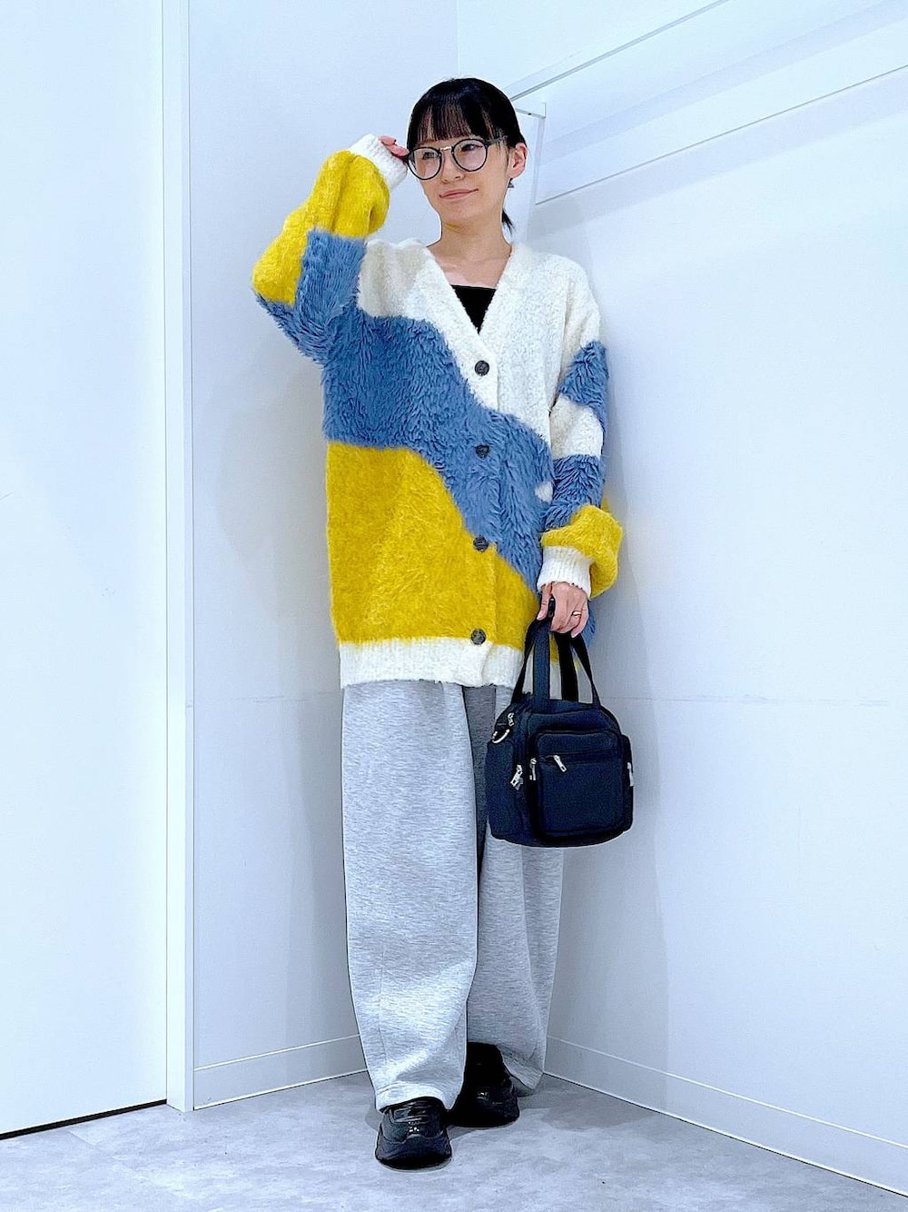 ブラック系のショルダーバッグ、ブラック系のローファー、イエロー系のカーディガン/ボレロを着用したレディースの秋コーディネートの1枚目の写真