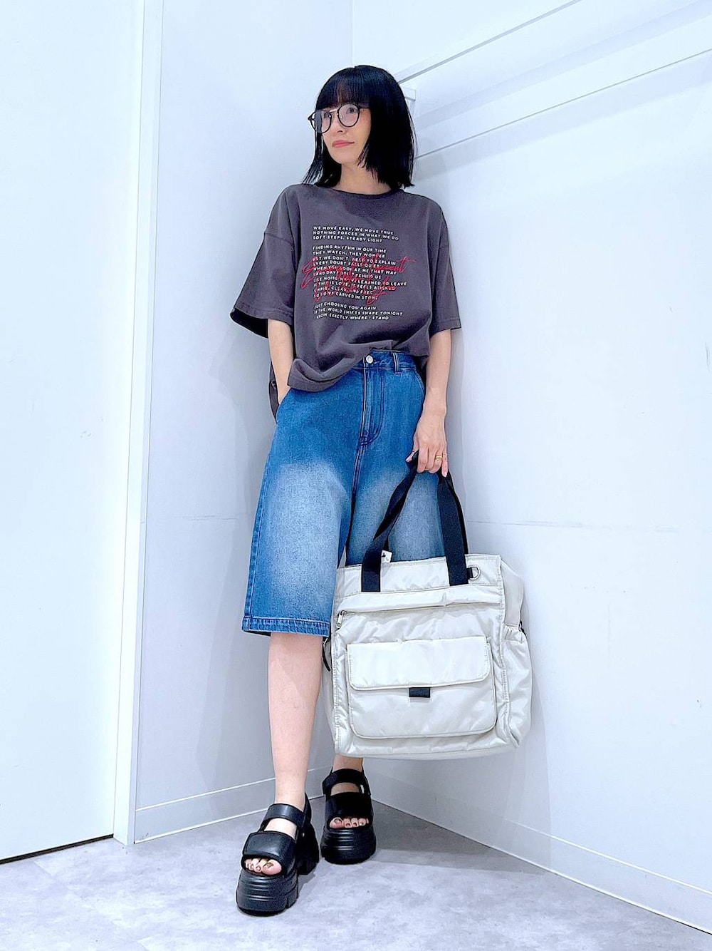 ブラック系のサンダル、ホワイト系のトートバッグ、グレー系のTシャツ/カットソーを着用したレディースの夏コーディネートの1枚目の写真