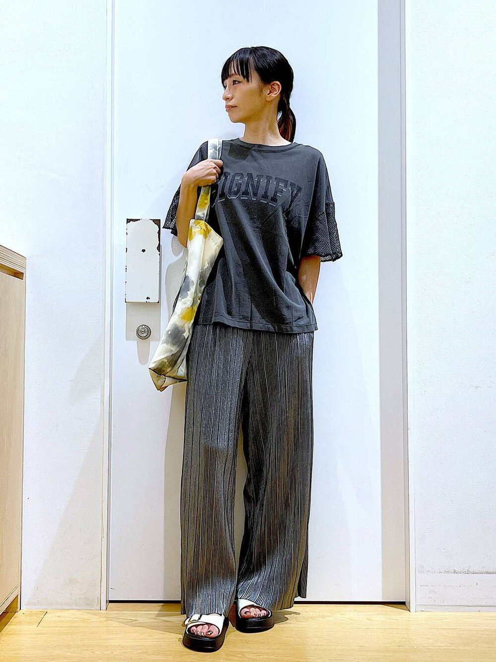 ホワイト系のサンダル、イエロー系のトートバッグ、グレー系のその他パンツを着用したレディースの秋コーディネートの1枚目の写真