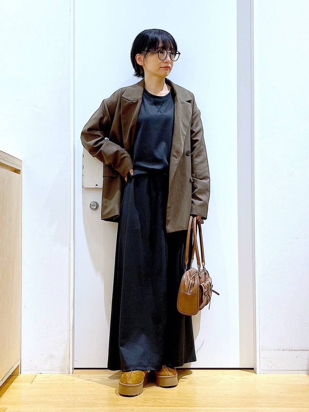 ベージュ系のスリッポン、ブラウン系のハンドバッグ、ブラウン系のテーラードジャケットを着用したレディースの秋コーディネートの1枚目の写真