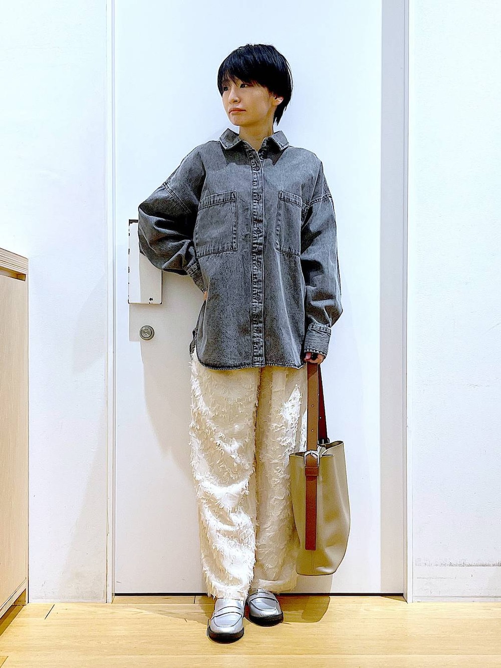 シルバー系のローファー、グレー系のシャツ/ブラウス、ベージュ系のショルダーバッグを着用したレディースの春コーディネートの1枚目の写真