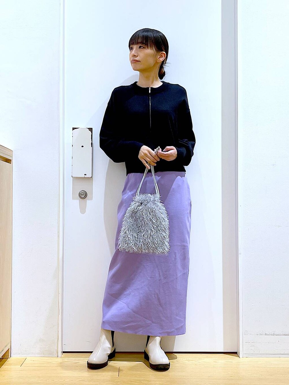 ブラック系のカーディガン/ボレロ、ベージュ系のブーツ、グレー系のショルダーバッグを着用したレディースの春コーディネートの1枚目の写真