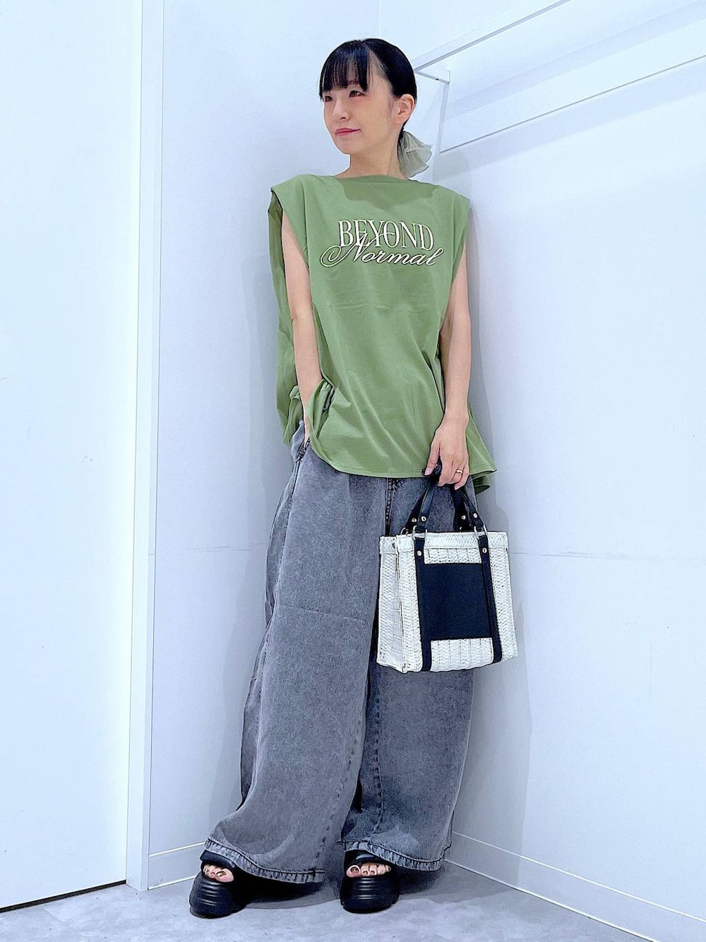 ホワイト系のショルダーバッグ、ブラック系のサンダル、グリーン系のTシャツ/カットソーを着用したレディースの夏コーディネートの1枚目の写真