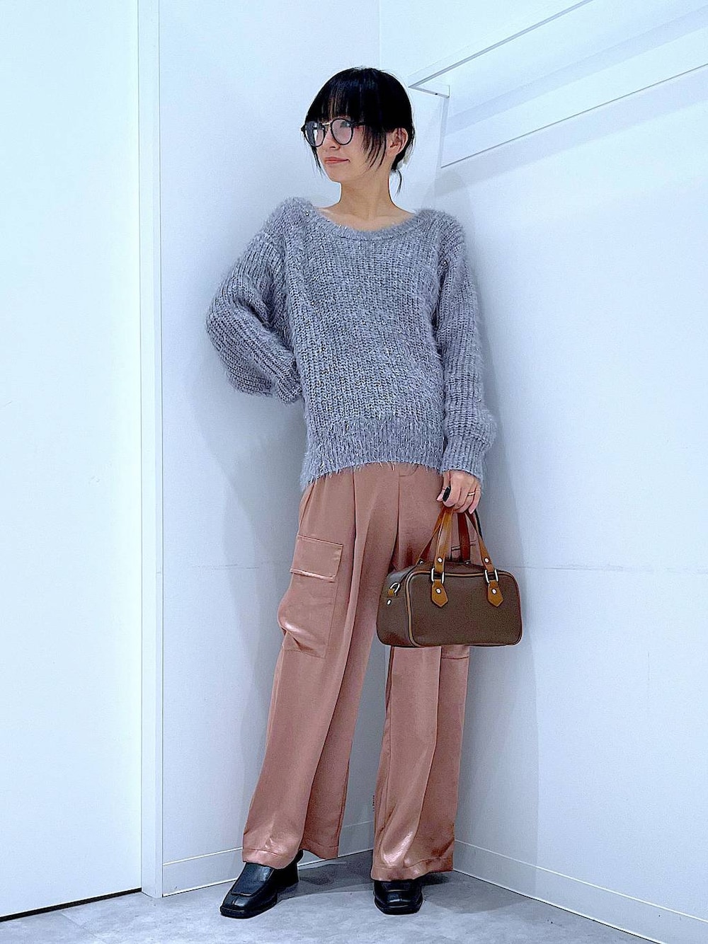 ブラック系のブーツ、ブラウン系のショルダーバッグ、ピンク系のカーゴパンツを着用したレディースの冬コーディネートの1枚目の写真