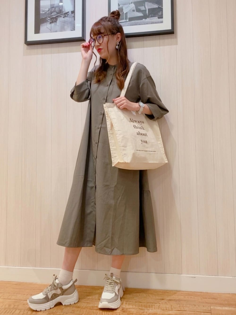 ホワイト系のトートバッグ、グリーン系のワンピース、ベージュ系のスニーカーを着用したレディースの秋コーディネートの1枚目の写真