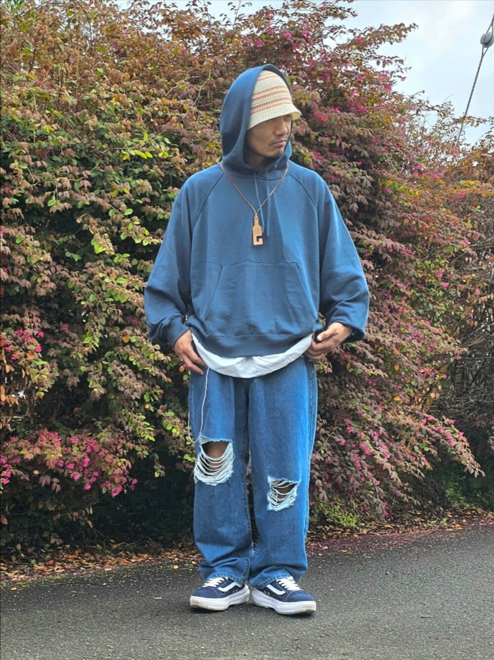 ブルー系のスニーカー、ブルー系のデニムパンツ、ブルー系のパーカーを着用したメンズの春コーディネートの1枚目の写真