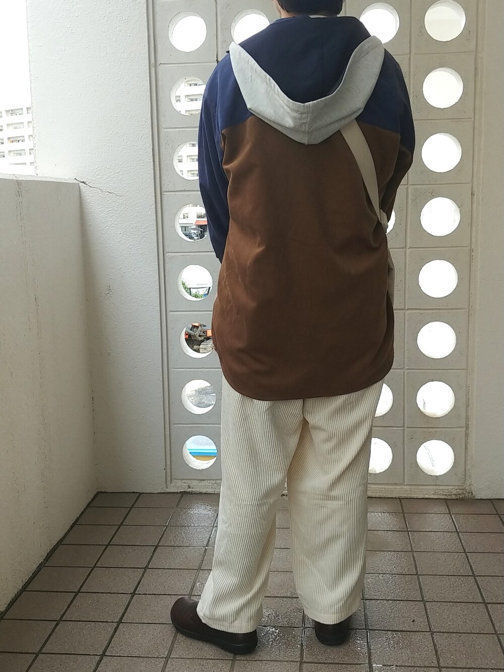 ホワイト系のその他パンツ、ブラウン系のブーツ、ホワイト系のトートバッグを着用したメンズの冬コーディネートの2枚目の写真