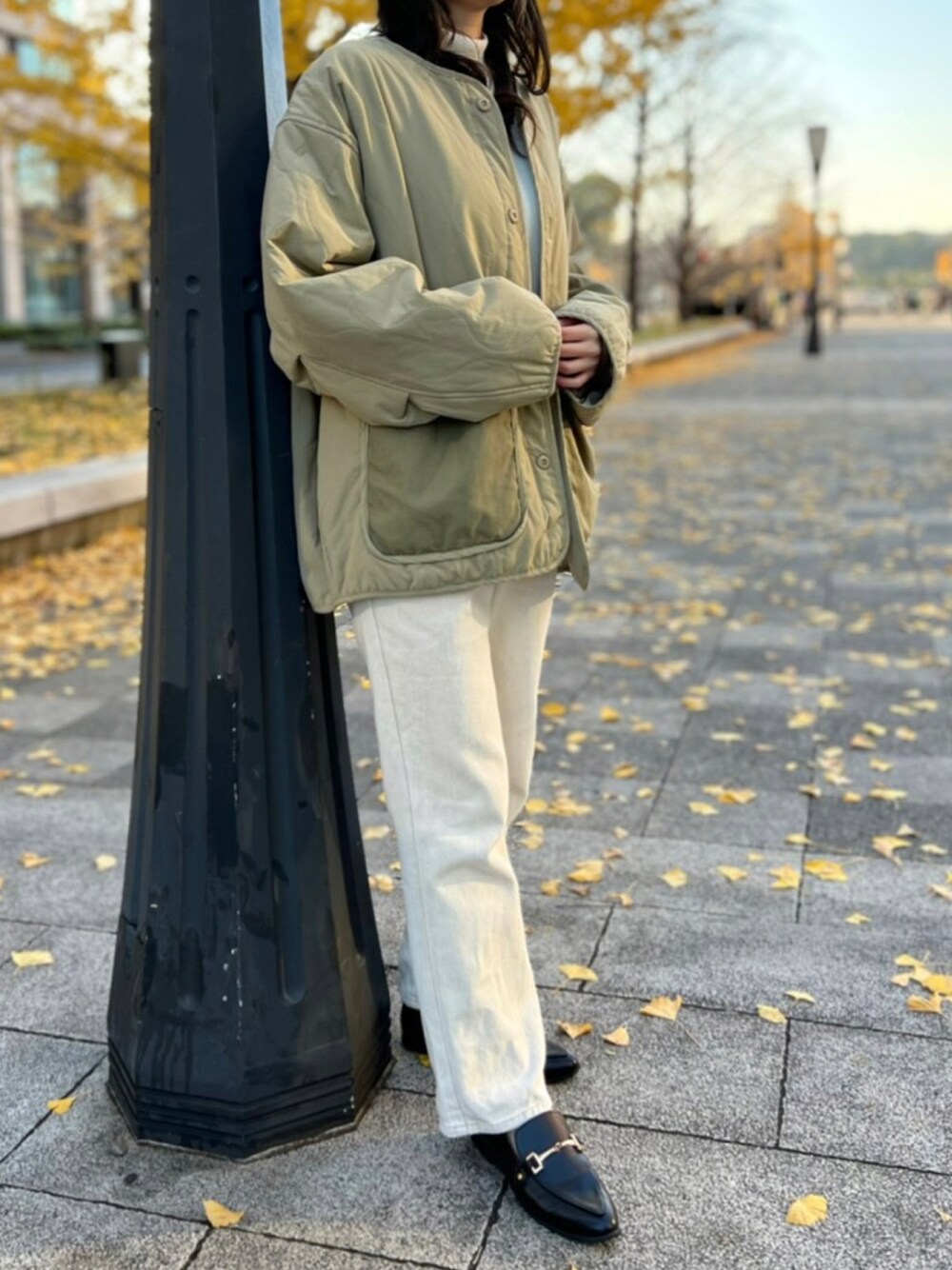 グリーン系のミリタリージャケット、ベージュ系のデニムパンツ、ブラック系のシューズを着用したレディースの冬コーディネートの1枚目の写真