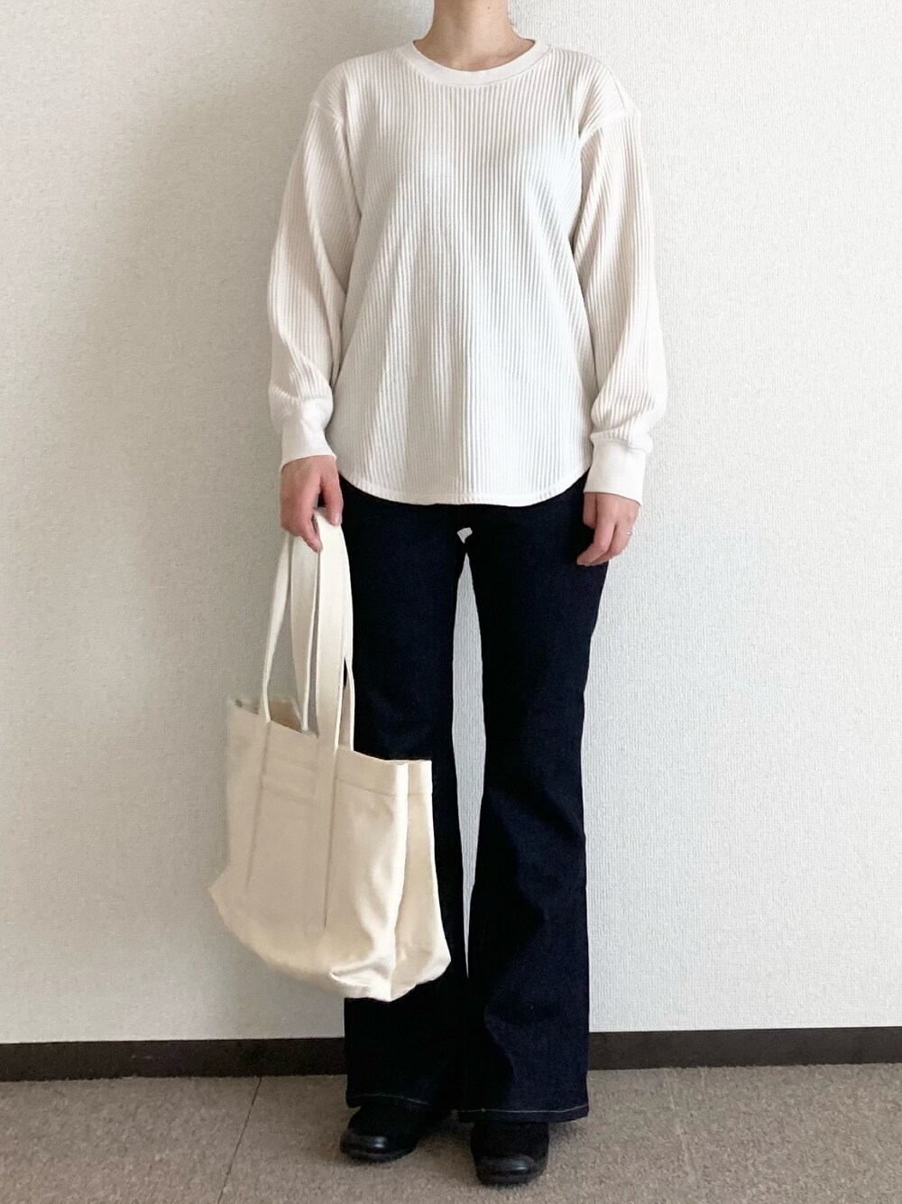 ホワイト系のトートバッグ、ブラック系のその他シューズ、ホワイト系のTシャツ/カットソーを着用したレディースの春コーディネートの1枚目の写真