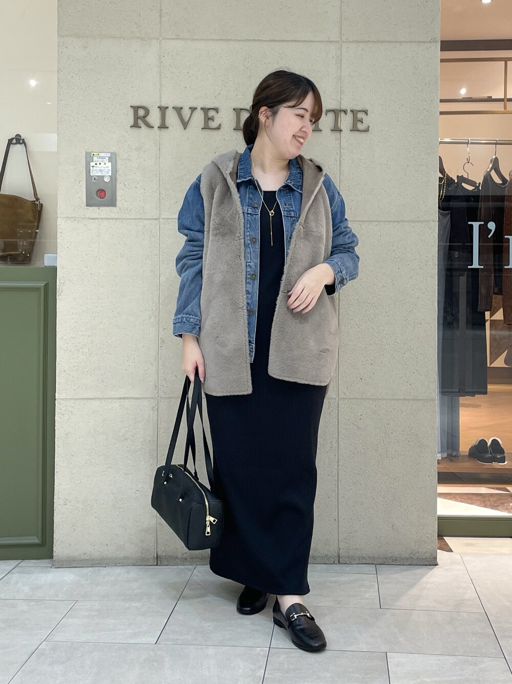 ブラック系のワンピース、ブラック系のローファー、ブラック系のショルダーバッグを着用したレディースの秋コーディネートの1枚目の写真