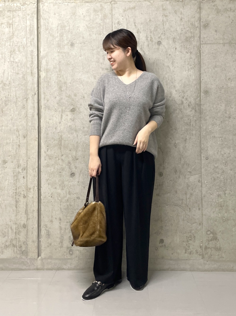 ブラック系のスラックス、グレー系のニット/セーター、ブラック系のローファーを着用したレディースの秋コーディネートの1枚目の写真