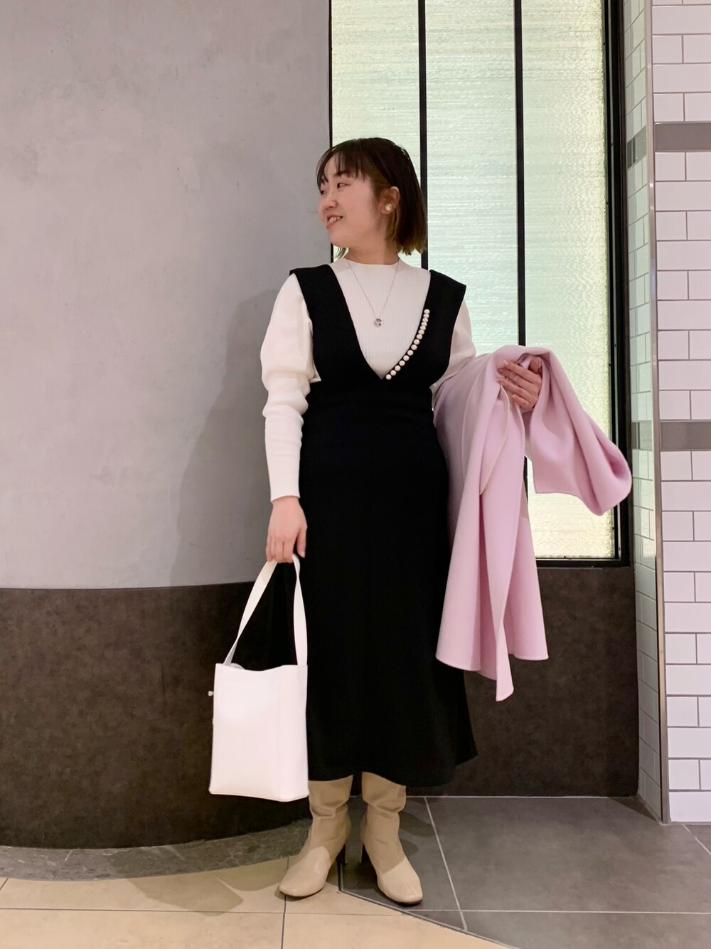 ブラック系のワンピース、ホワイト系のニット/セーター、ホワイト系のトートバッグを着用したレディースの冬コーディネートの1枚目の写真