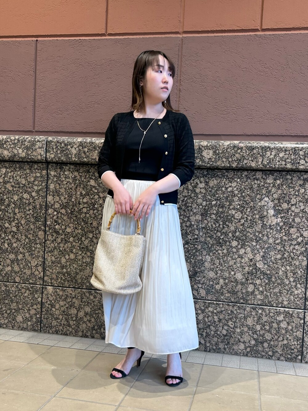 ブラック系のニット/セーター、ブラック系のカーディガン/ボレロ、ベージュ系のトートバッグを着用したレディースの春コーディネートの1枚目の写真