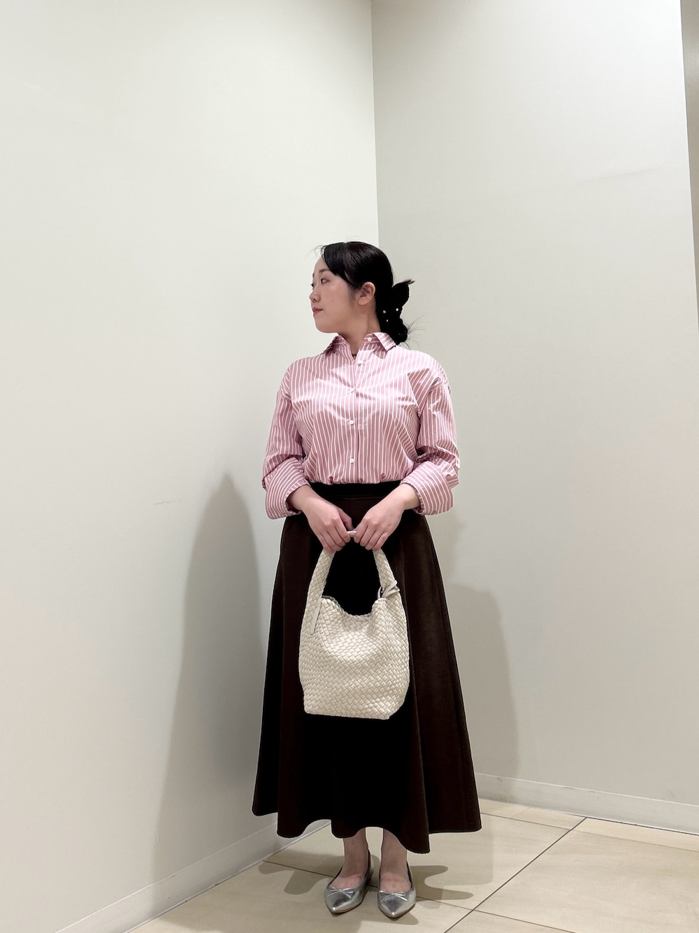 ピンク系のシャツ/ブラウス、ブラウン系のスカート、ホワイト系のショルダーバッグを着用したレディースの秋コーディネートの1枚目の写真