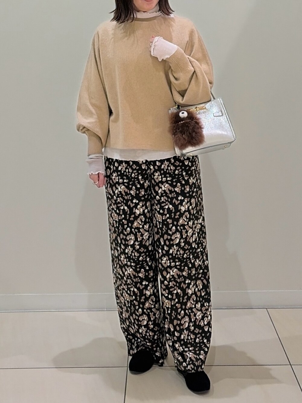 ベージュ系のニット/セーター、ホワイト系のTシャツ/カットソー、シルバー系のショルダーバッグを着用したレディースの冬コーディネートの1枚目の写真