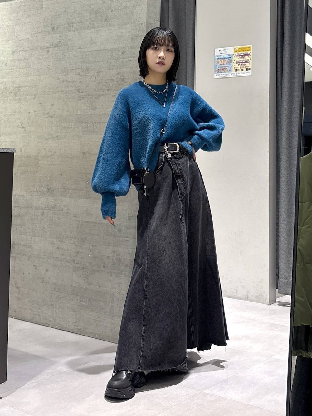 グレー系のタンクトップ、ブルー系のニット/セーター、ブラック系のブーツを着用したレディースの秋コーディネートの1枚目の写真