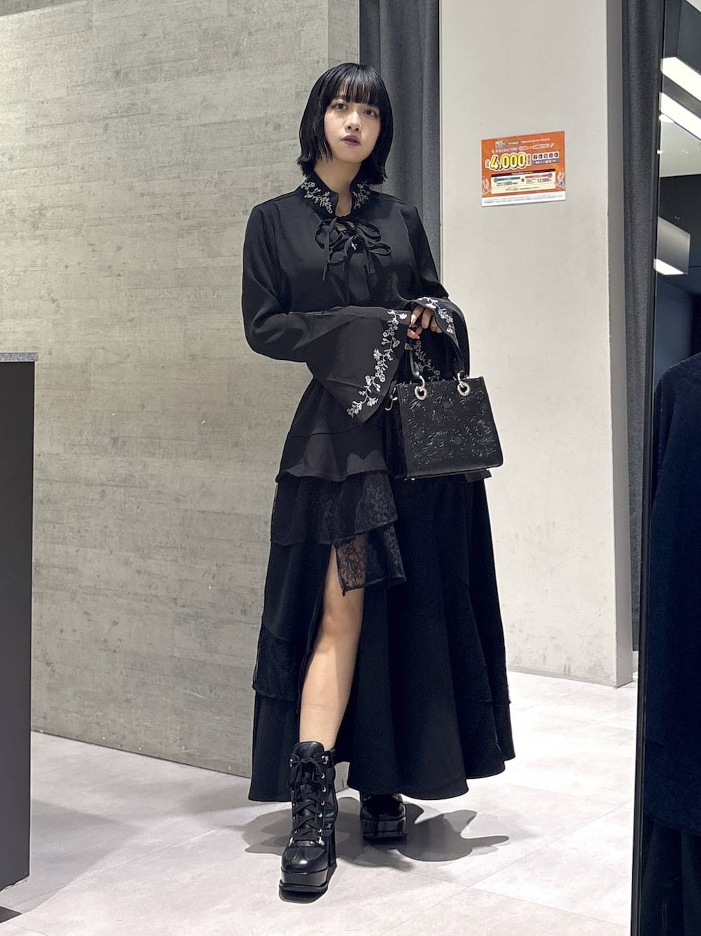 ブラック系のショルダーバッグ、ブラック系のシャツ/ブラウス、ブラック系のブーツを着用したレディースの秋コーディネートの1枚目の写真