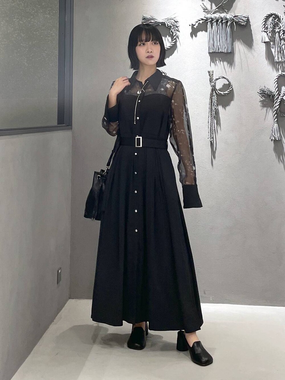 グレー系のタンクトップ、ブラック系のパンプス、ブラック系のショルダーバッグを着用したレディースの夏コーディネートの1枚目の写真