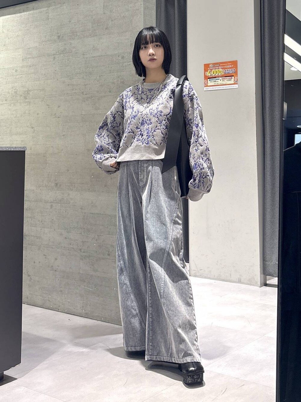 グレー系のタンクトップ、ブラック系のトートバッグ、グレー系のブーツを着用したレディースの秋コーディネートの1枚目の写真