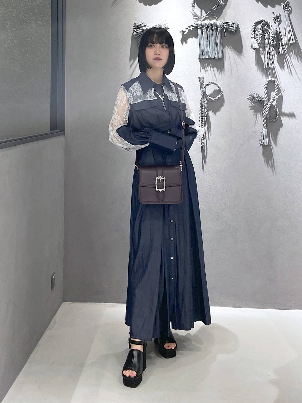 ブラック系のタンクトップ、ブラック系のサンダル、ブラウン系のショルダーバッグを着用したレディースの夏コーディネートの1枚目の写真